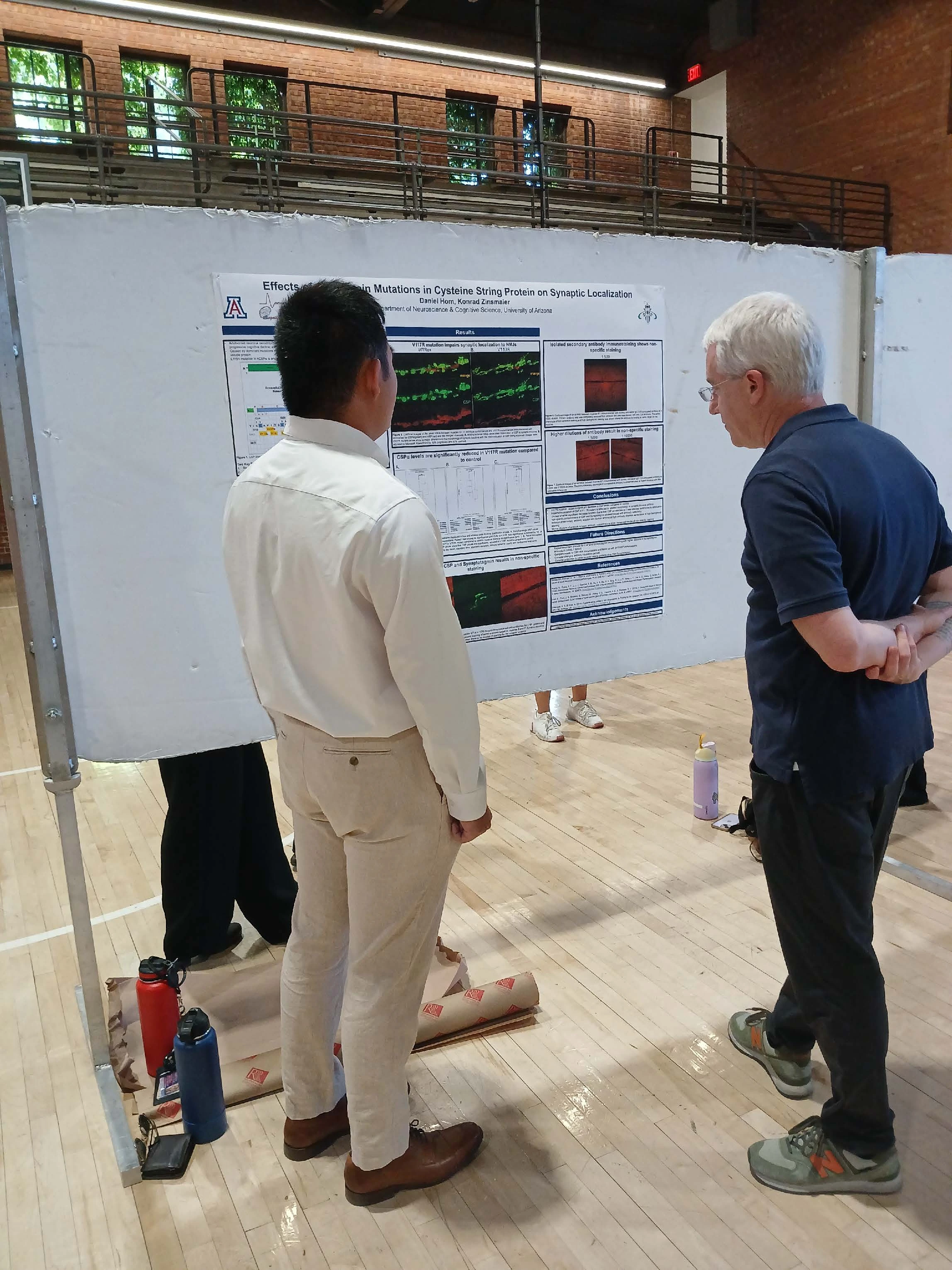 Undergraduate student standing next to their Capstone Project