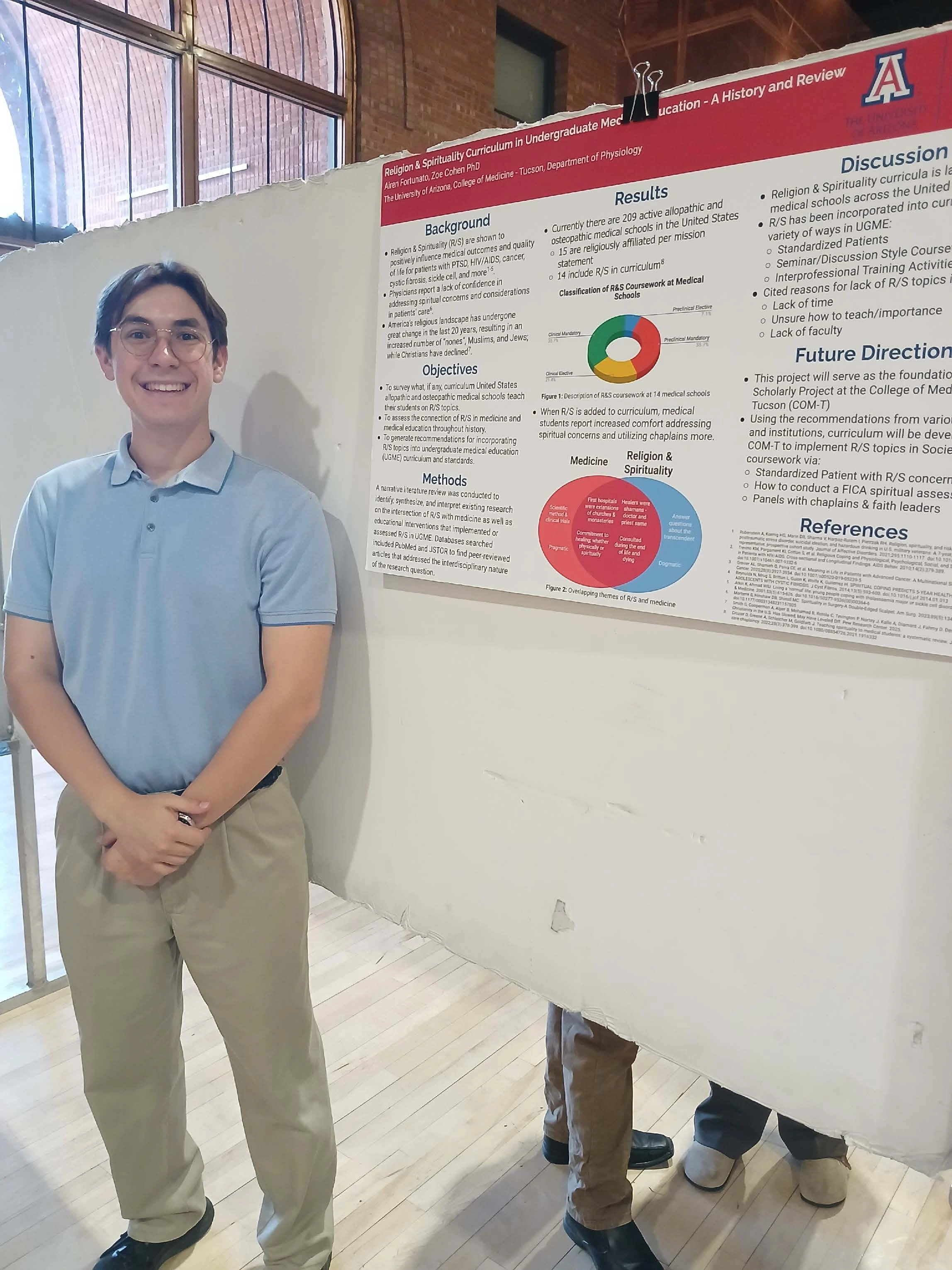 Undergraduate student standing next to their Capstone Project