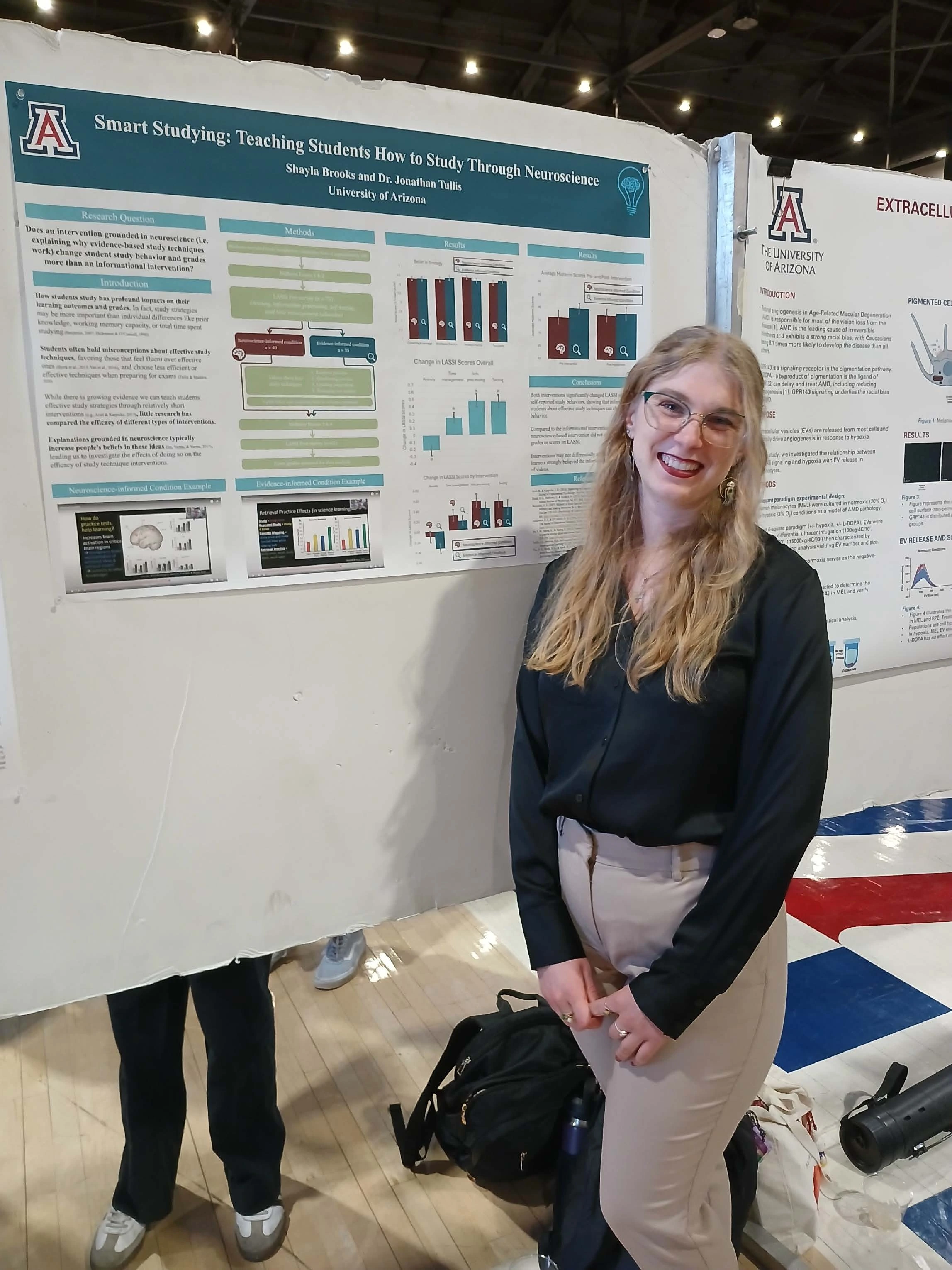 Undergraduate student standing next to their Capstone Project