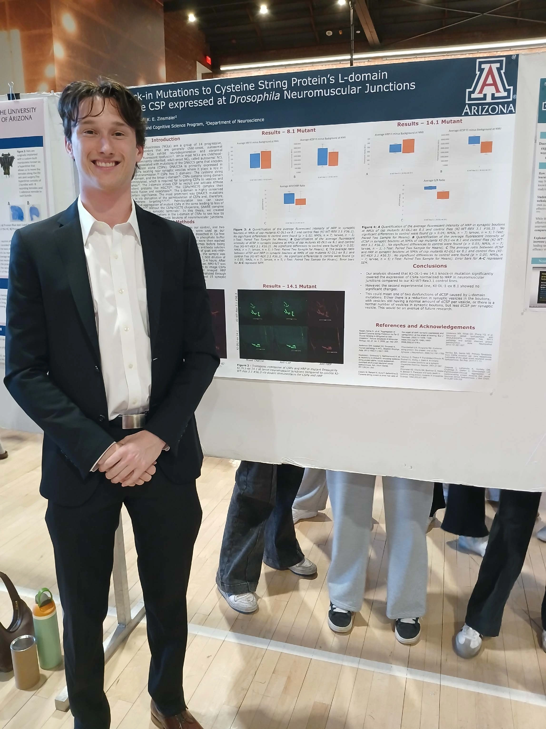 Undergraduate student standing next to their Capstone Project