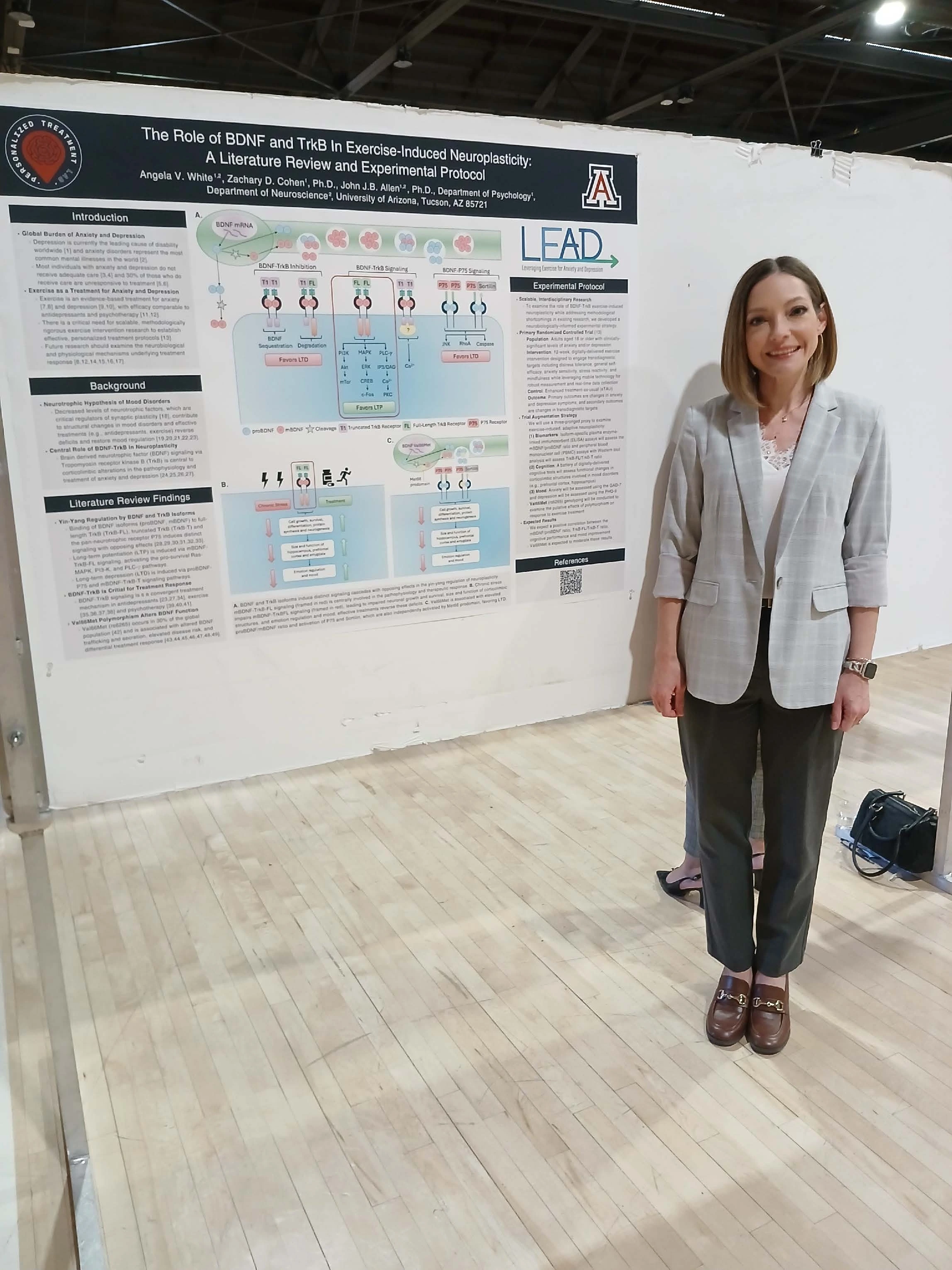 Undergraduate student standing next to their Capstone Project