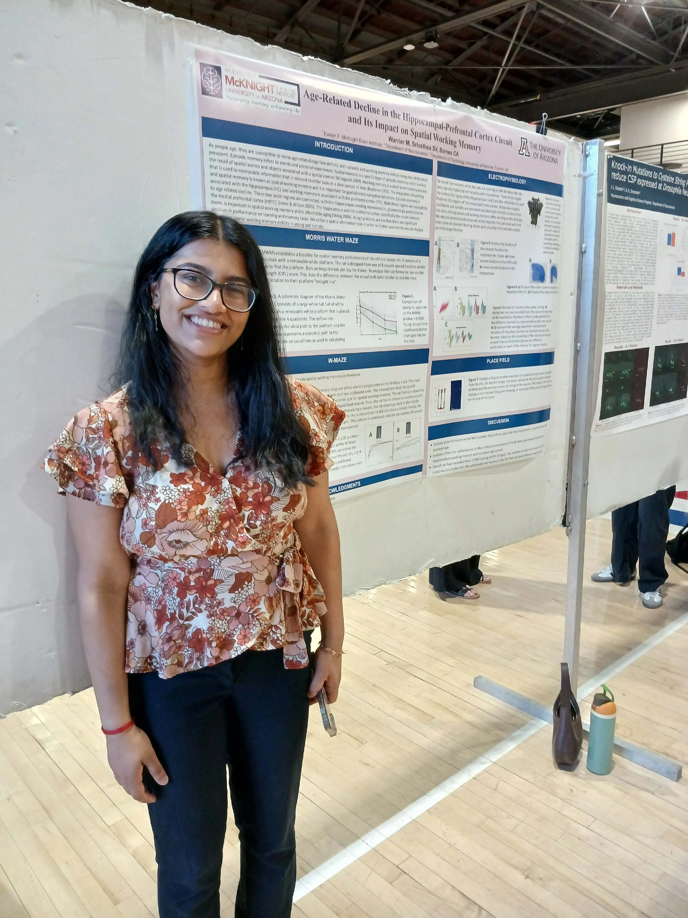 Undergraduate student standing next to their Capstone Project