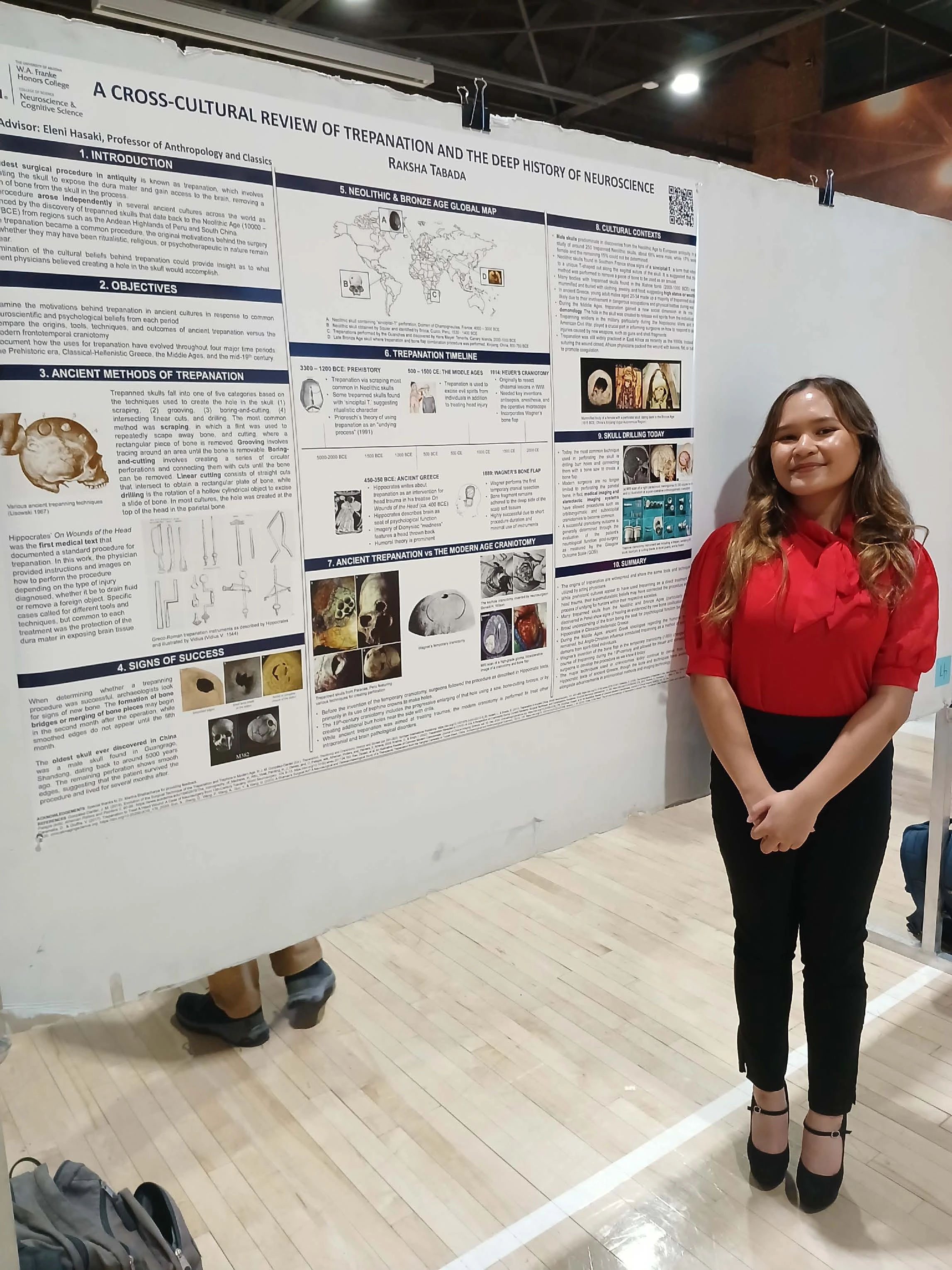 Undergraduate student standing next to their Capstone Project