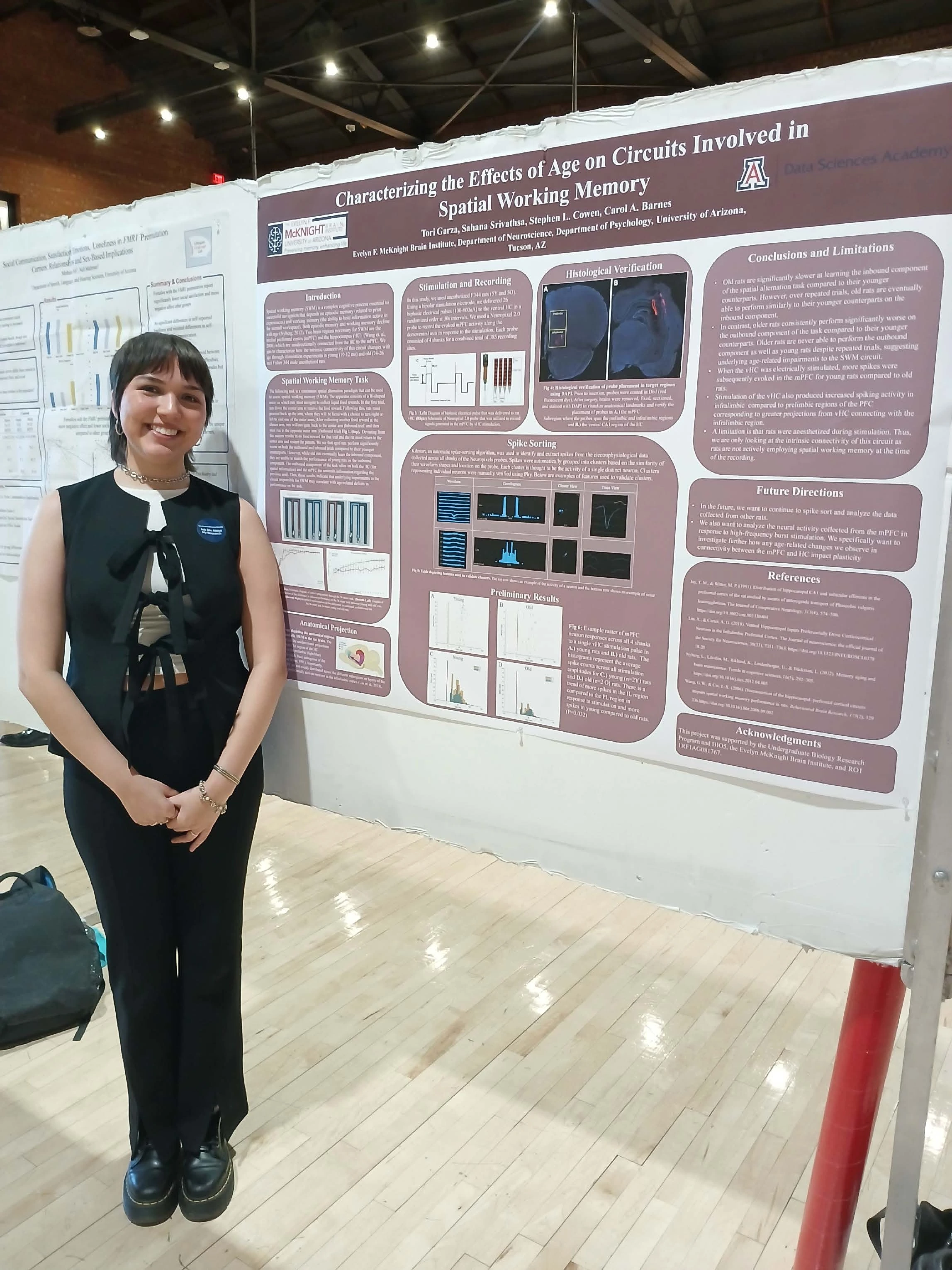 Undergraduate student standing next to their Capstone Project