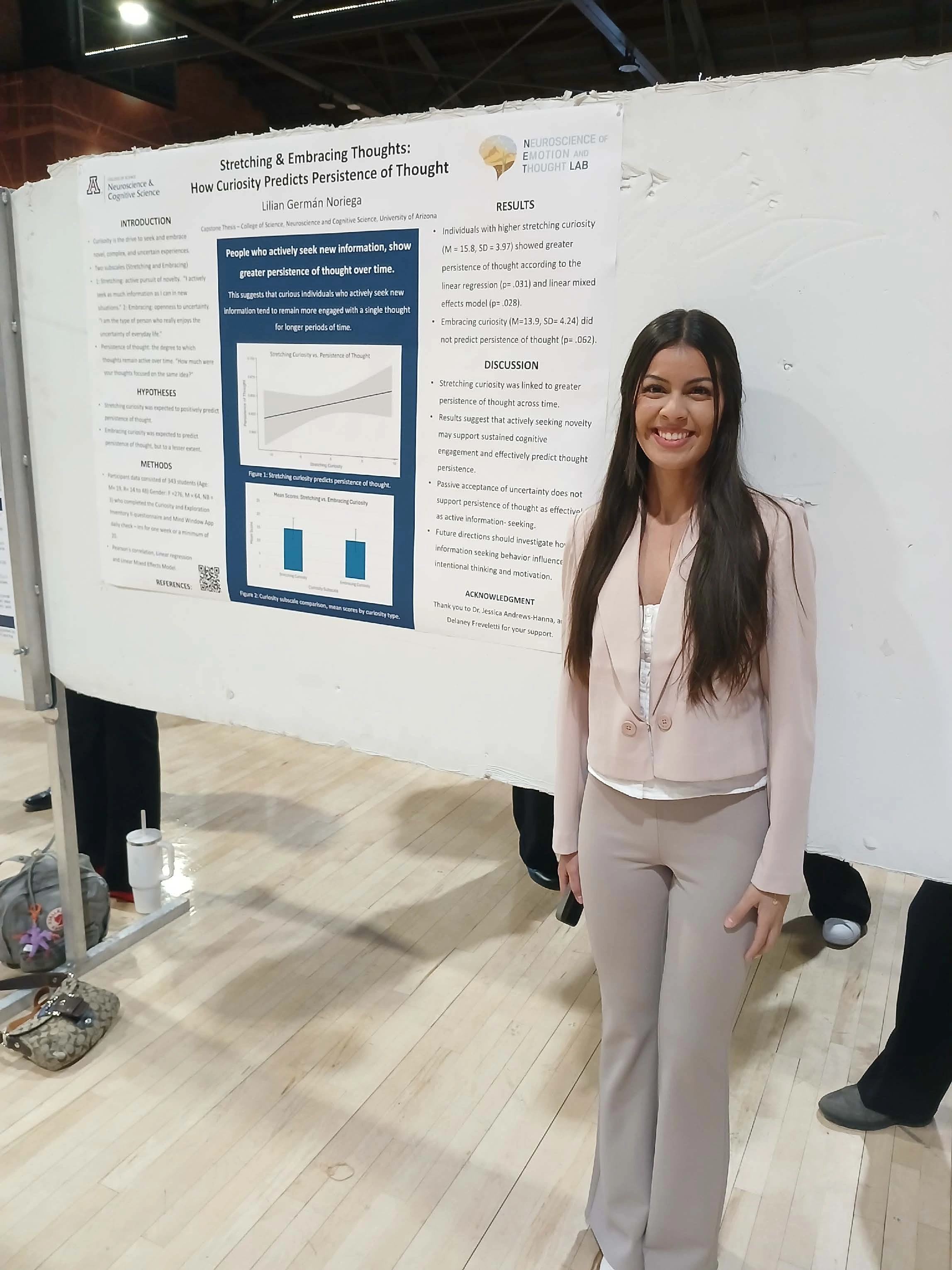 Undergraduate student standing next to their Capstone Project