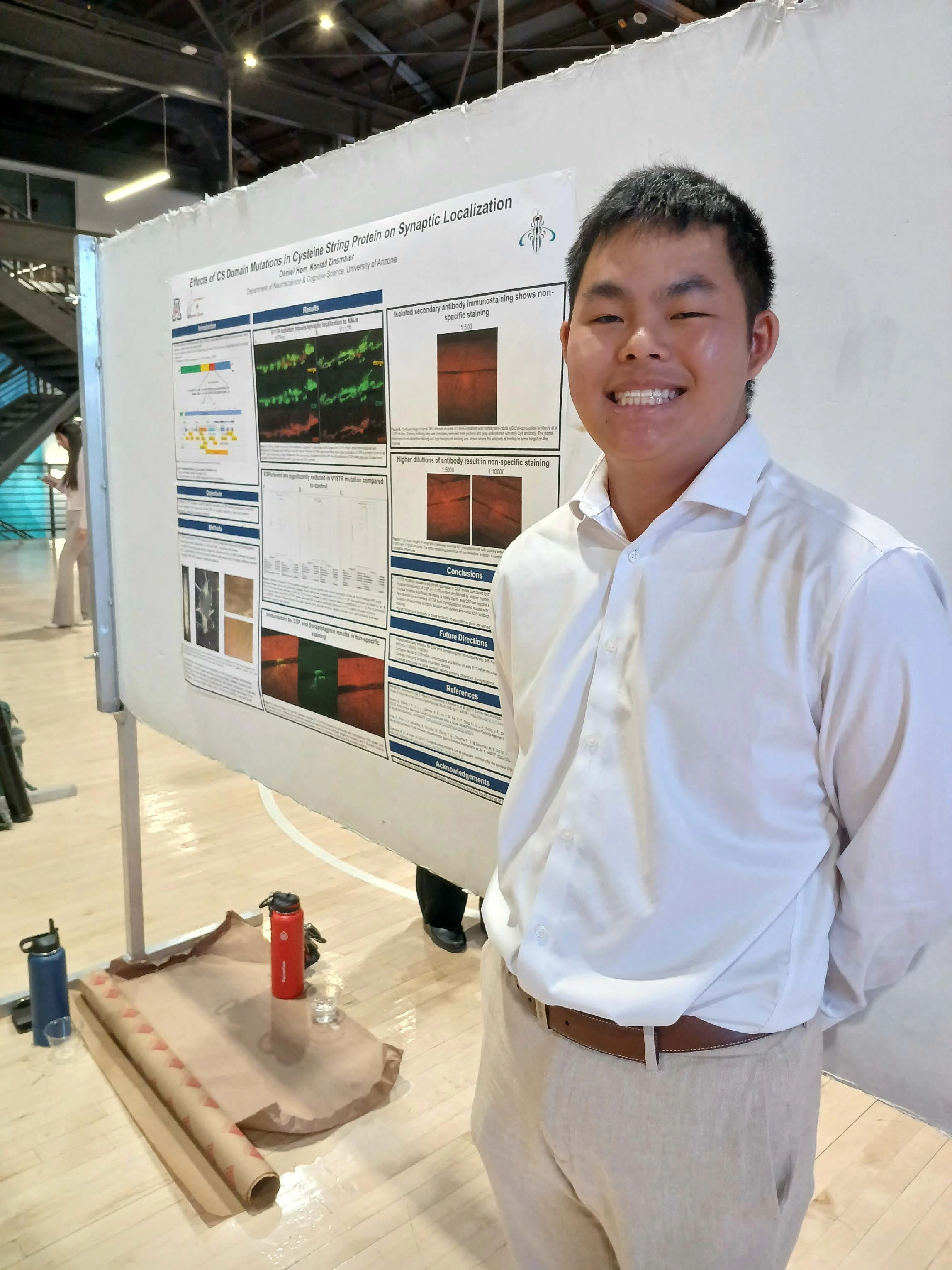 Undergraduate student standing next to their Capstone Project