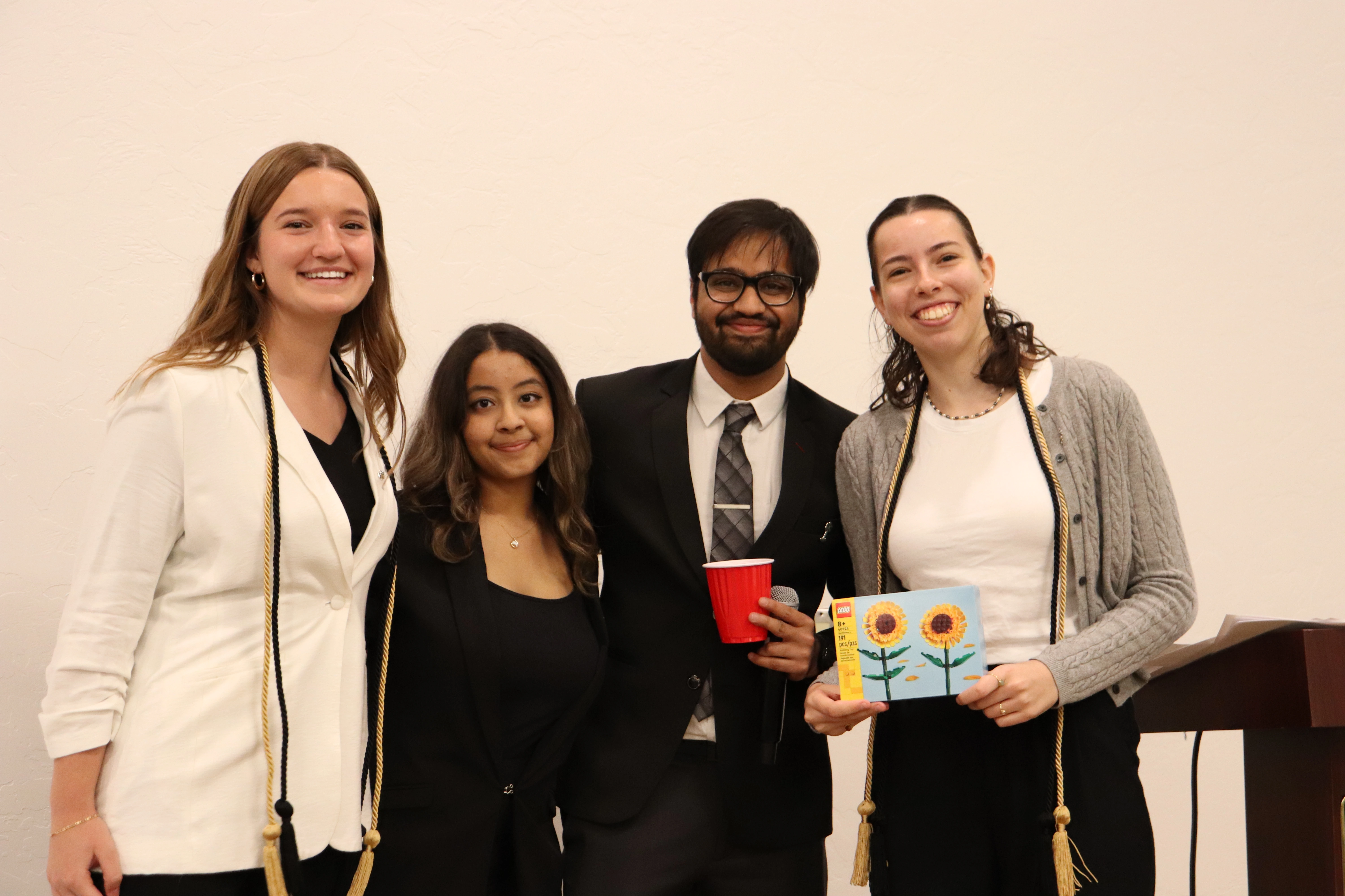 Four NSCS students grouped together for a photo. The rightmost one has a 191 piece sunflower lego set in their hands.  